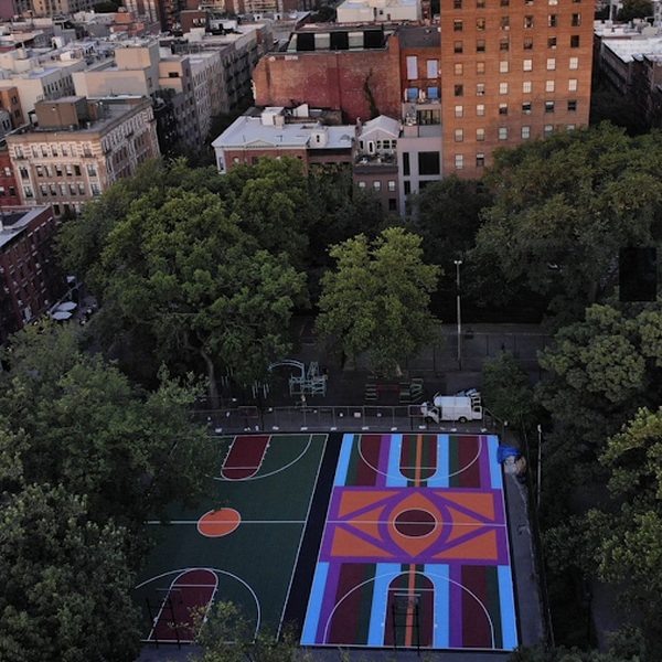 The basketball courts seen from above, surrounded by trees