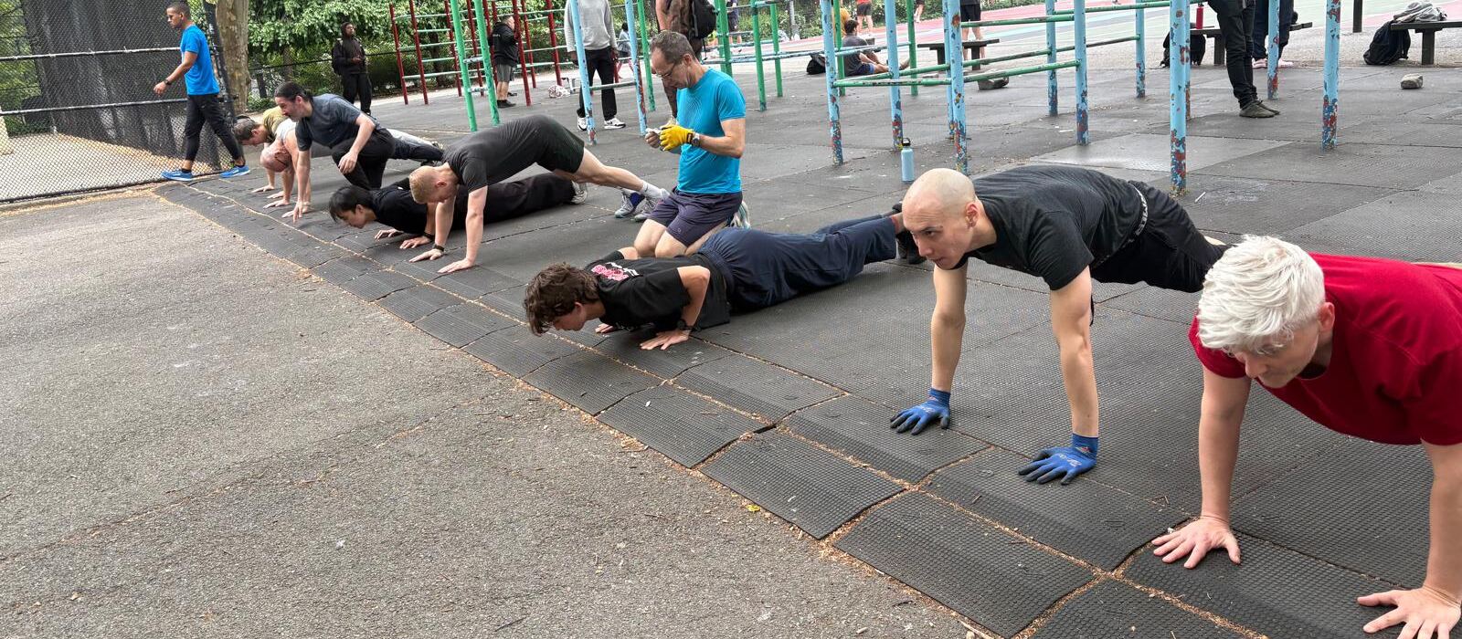 People doing push-ups in a row at the Tompkins calisthenics area